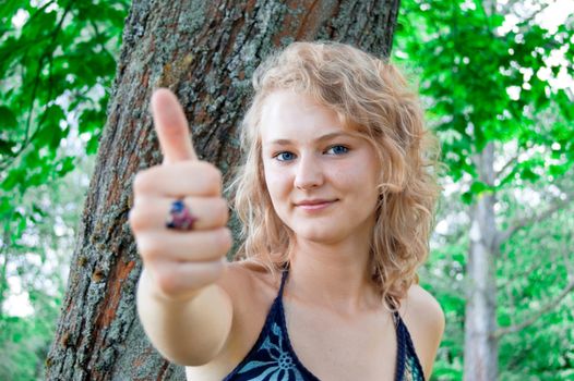 Young beautiful girl shows a thumbs-up gesture.
