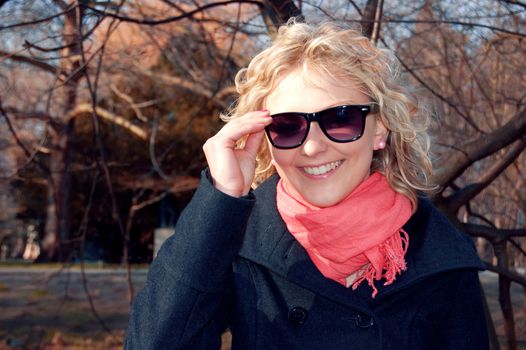 Beautiful young girl puts on her sunglasses.