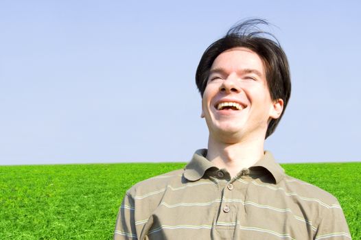Emotion conceptual image. Teenager laughing against the fields and blue sky.