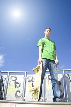 Skateboarder conceptual image. Teenage skateboarder standing on the ramp.