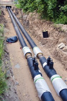 two black plastic central heating pipes coming out of house during renovation