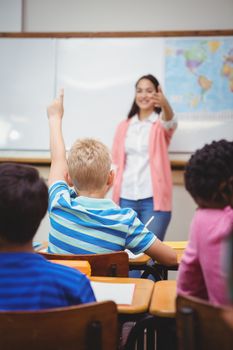 Student raising hand to ask a question at the elementary school