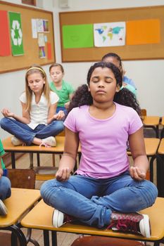 Pupils meditating on classroom desks at the elementary school