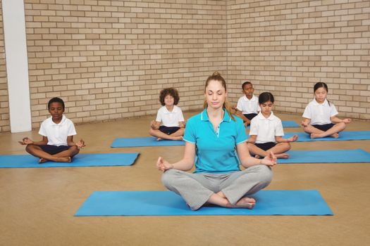 Students and teacher doing yoga pose at the elementary school