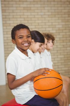 Student holding basketball with fellow players at the elementary school