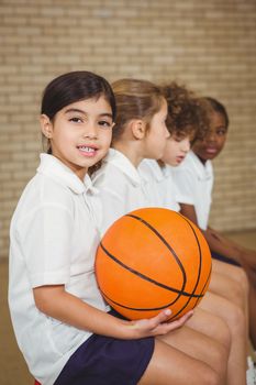 Student holding basketball with fellow players at the elementary school