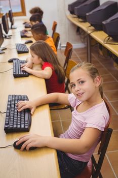 Smiling student using a computer at the elementary school
