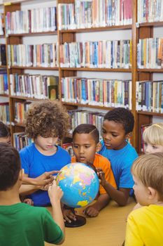 Students pointing at a globe at the elementary school