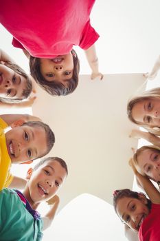 Cute pupils showing large poster on elementary school campus