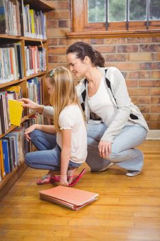 Teacher helping a student pick a book at the elementary school