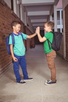 Pupils giving each other a high five on the elementary school grounds