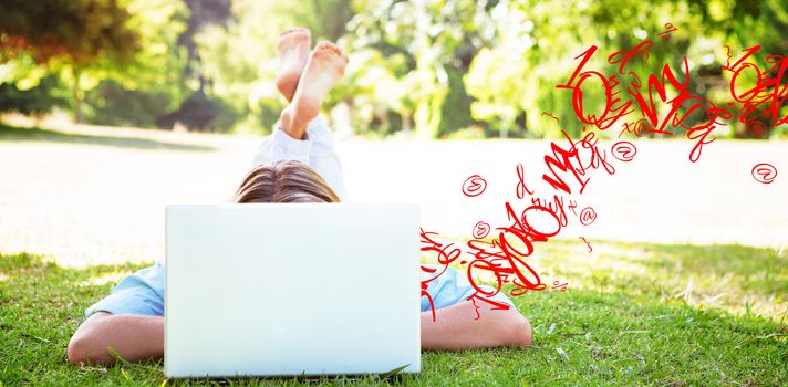 letter and number jumble against pretty woman using laptop in park