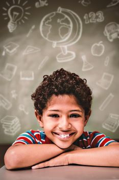 Education doodles against little boy smiling in classroom