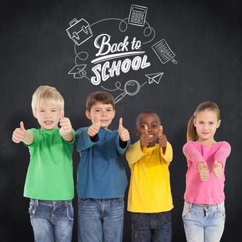 Cute kids showing thumbs up against blackboard
