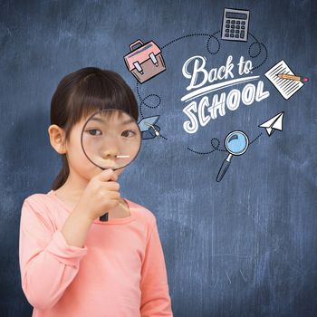 Pupil looking through magnifying glass against blue chalkboard