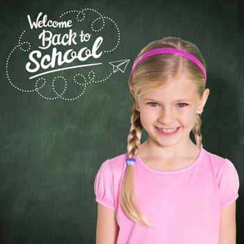 Cute girl smiling at camera against green chalkboard