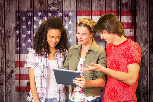 Students using digital tablet in library against composite image of usa national flag