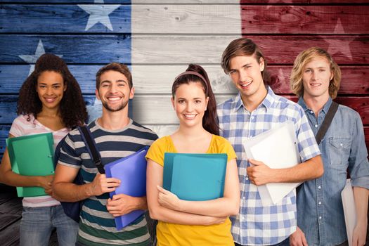 Students holding folders in college against composite image of usa national flag