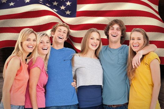 A group of friends holding each other and smiling against composite image of digitally generated united states national flag