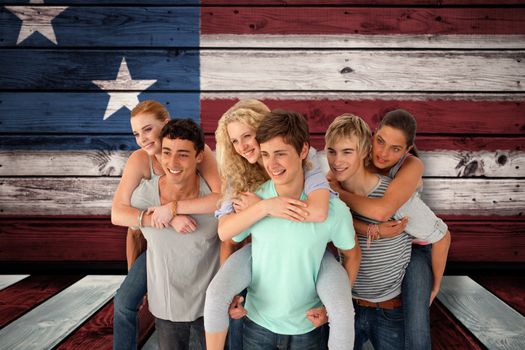 Teenagers giving their friends piggyback rides against composite image of usa national flag