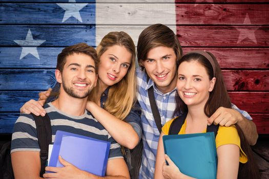 Students holding folders at college corridor against composite image of usa national flag