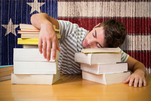 Student asleep in the library against composite image of usa national flag