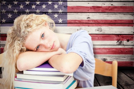 Tired teeenager sleeping in a library against composite image of usa national flag