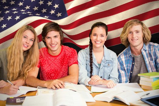 College students doing homework in library against composite image of digitally generated united states national flag