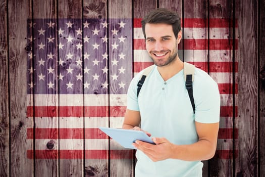 Student using tablet pc against composite image of usa national flag