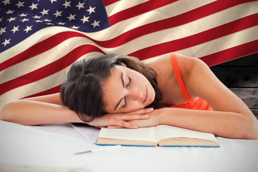 Sleeping student head on her books against composite image of digitally generated united states national flag