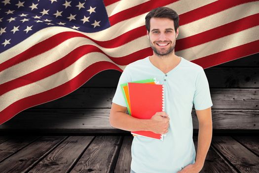 Student holding notepad against composite image of digitally generated united states national flag