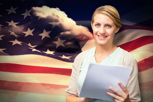 Smiling teacher against composite image of digitally generated american flag rippling