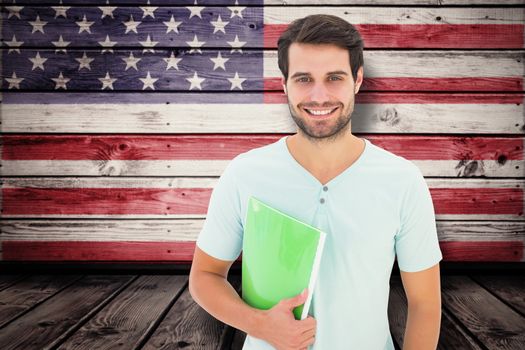 Student holding notepad against composite image of usa national flag