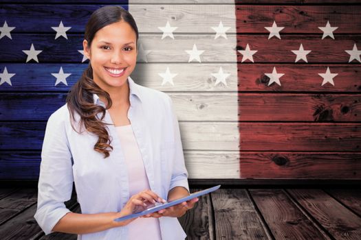 Woman using tablet pc against composite image of usa national flag