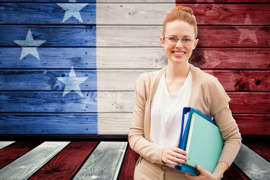 Teacher with books against composite image of usa national flag