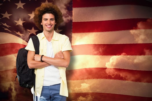 Young man with arms crossed in office corridor against composite image of digitally generated united states national flag