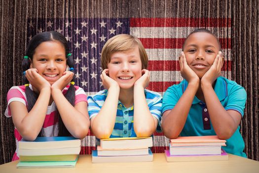 Cute pupils looking at camera in library  against composite image of usa national flag