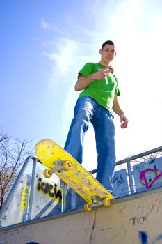 Sport conceptual image.  Teenage skateboarder standing on the ramp with skateboard.