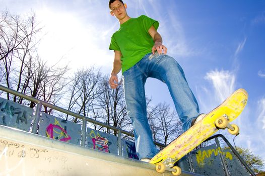 Sport conceptual image.  Teenage skateboarder standing on the ramp with skateboard.