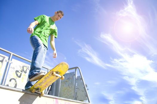 Sport conceptual image. Teenage skateboarder standing on the ramp with skateboard.