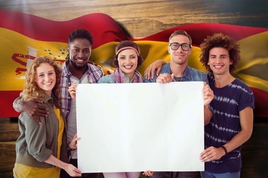 Fashion students smiling at camera together against digitally generated spain flag rippling