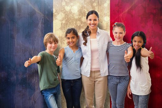 Cute pupils and teacher smiling at camera in computer class  against france flag in grunge effect