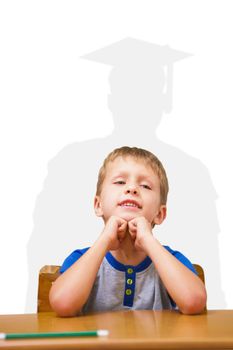 Smiling pupil sitting at his desk  against silhouette of graduate
