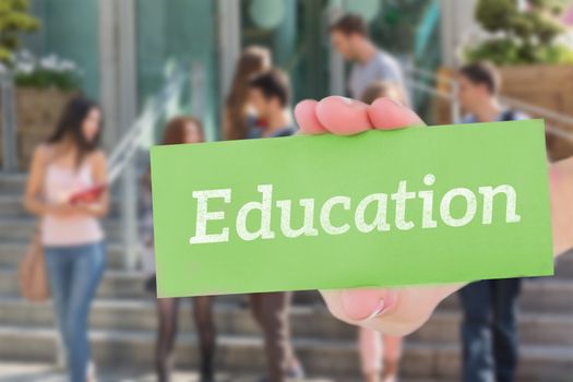 The word education and hand showing card against happy students walking and chatting outside