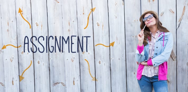 The word assignment against thoughtful woman holding paint brush