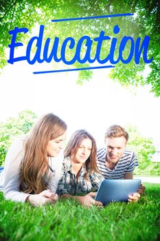 The word education against happy students using tablet pc outside