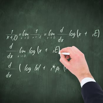 Hand of businessman writing with a white chalk against green chalkboard