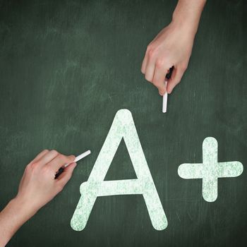 Hand writing with chalk against green chalkboard