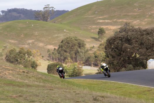 Two superbikes under full power exiting out of a corner.