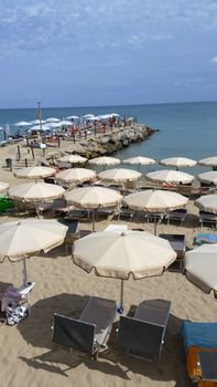 Many umbrellas on the Beach of San Remo in Italia. Beautiful Sea in Background